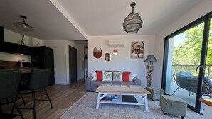 A modern living space with a kitchen, dining area, and seating area with a view. - 3-room apartment with a view of the Citadel, a terrace, and a free garage, just 500 meters from the sea! (Calvi)