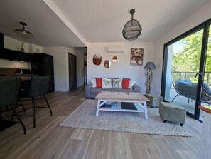 A modern living space with a kitchen, dining area, and seating area with a view. - 3-room apartment with a view of the Citadel, a terrace, and a free garage, just 500 meters from the sea! (Calvi)