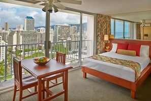 Ein Hotelzimmer mit Bett, Esstisch und Blick auf die Stadtlandschaft.