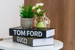 Eine Reihe von Büchern mit den Titeln 'TOM FORD' und 'GUCCI' auf einem weißen Tisch.