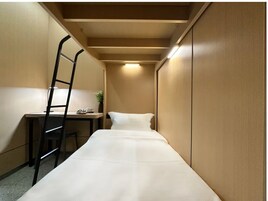 Una habitación pequeña con una cama, un escritorio y una silla.