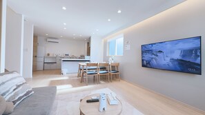 A modern living room with a TV, sofa, and dining area. - SHOTENSHITA (Osaka)