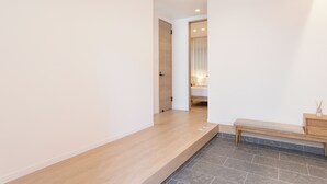 Ein Flur mit einer Bank, einer Holztür und einem kleinen Tisch mit einer Kerze.