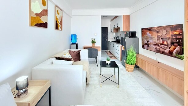 A modern living room with a sofa, coffee table, and artwork on the wall. - Shamms smarthome Studio 2 (Nairobi)