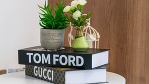 A stack of books with 'TOM FORD' and 'GUCCI' titles on a white table. - Shamms smarthome Studio 2 (Nairobi)