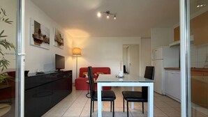 Eine moderne Küche mit Essbereich, Fernseher und Kunstwerken an den Wänden.