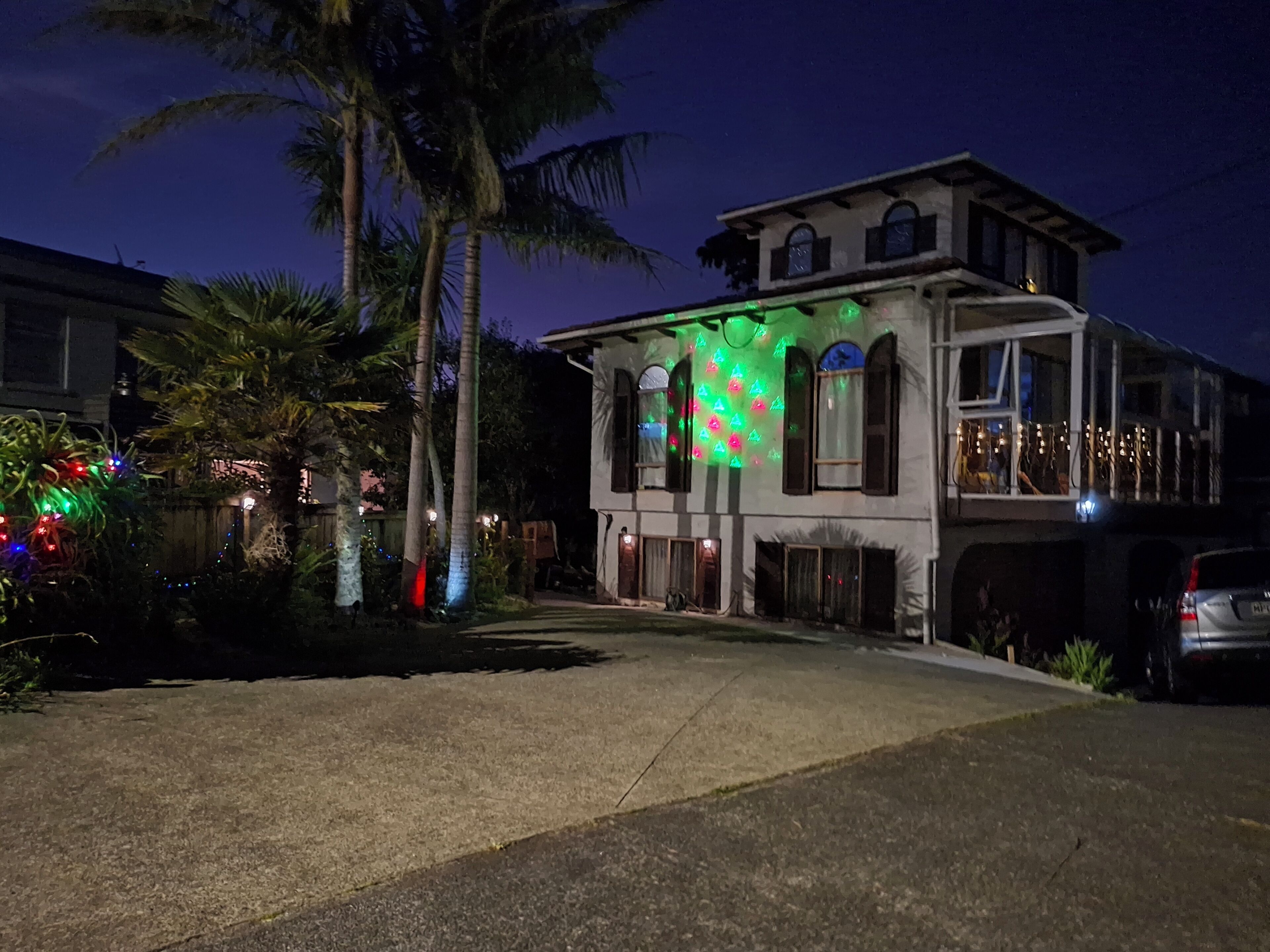A two-story building with a balcony, a garage, and a driveway.