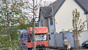 Ein roter SDCC-LKW parkt in einer Wohnstraße.