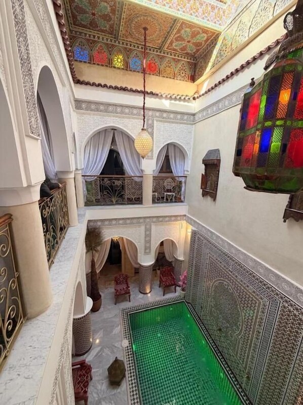 An indoor courtyard with a green pool, arches, and intricate tile work. - Riad mon pote Marrakech (Marrakesh)