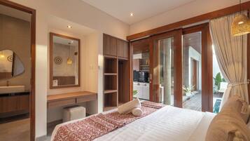 Quarto de hotel moderno com uma cama grande, escrivaninha embutida, toucador com espelho e porta de vidro deslizante para uma varanda.