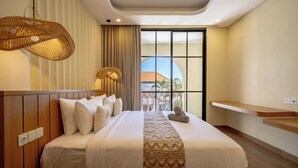 Ein Hotelzimmer mit einem großen Bett, einer hängenden Leuchte, Blick ins Freie und einem Holzkopfteil.