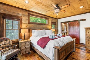 A wooden bedroom with a bed, nightstands, a chair, a dresser, and a ceiling fan. - Mt View, Spa, Firepit, EV Chrgr & Pvt Riverside Pk (Blue Ridge)