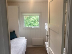 A narrow room with a bed, a window, and a radiator. - 4 Star Holiday Home in Harboore (Harboore)
