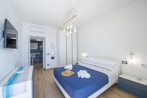 Een moderne hotelkamer met een bed, nachtkastje en spiegel.