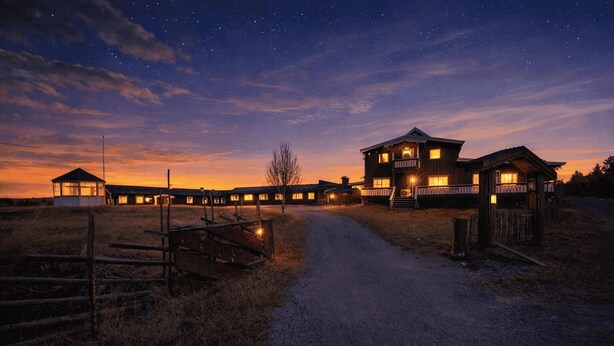 Un albergue rústico con varias cabañas, un sendero de tierra y un cielo estrellado.