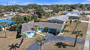 A residential area with houses, a swimming pool, and palm trees.