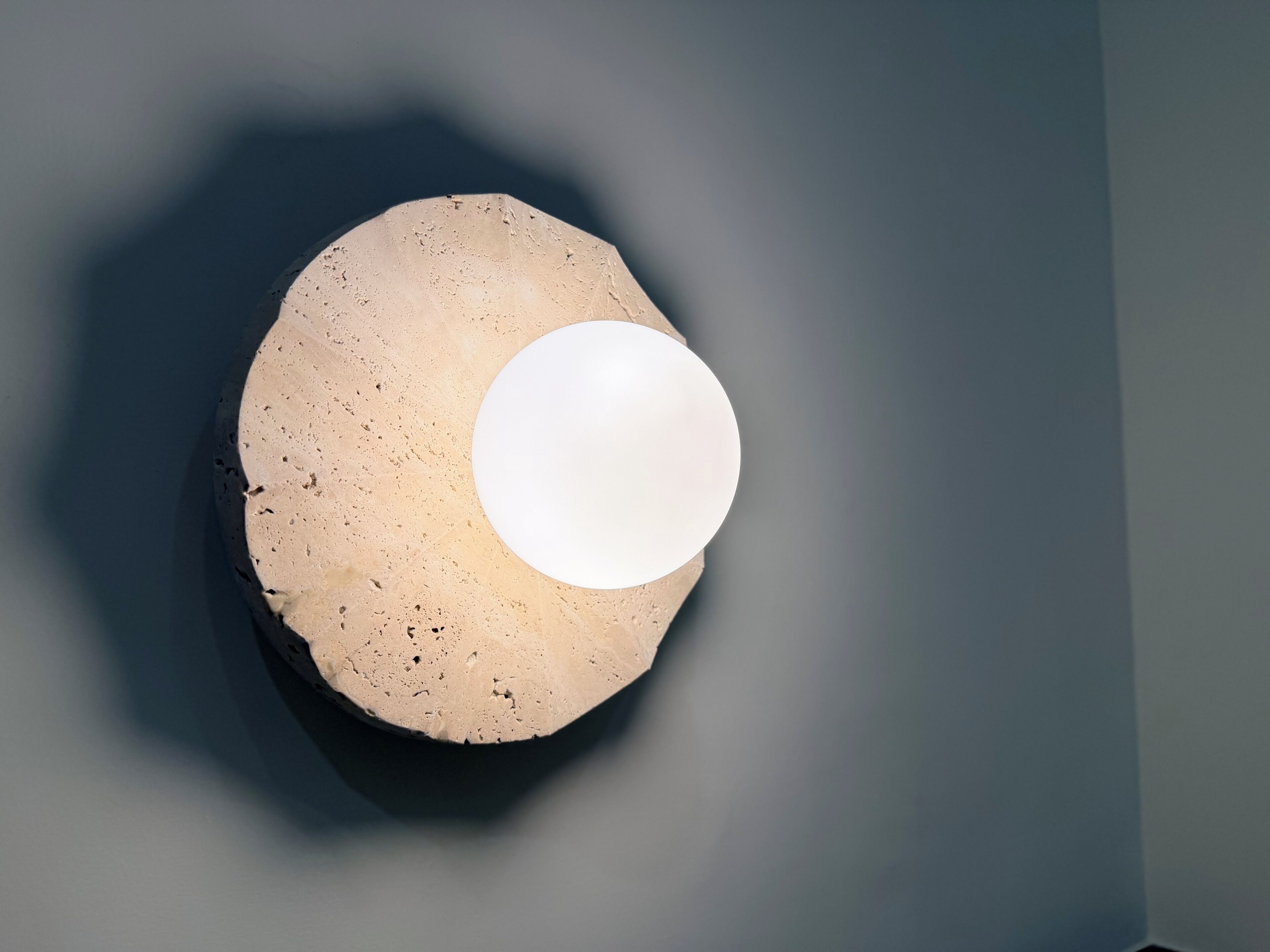 A circular light fixture with a textured surface and a central white sphere.