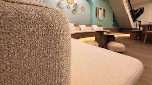 Un interior moderno con un sofá, una pared decorada y una escalera.