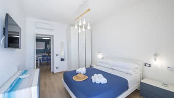 Una habitación de hotel moderna con cama, mesita de noche y espejo.