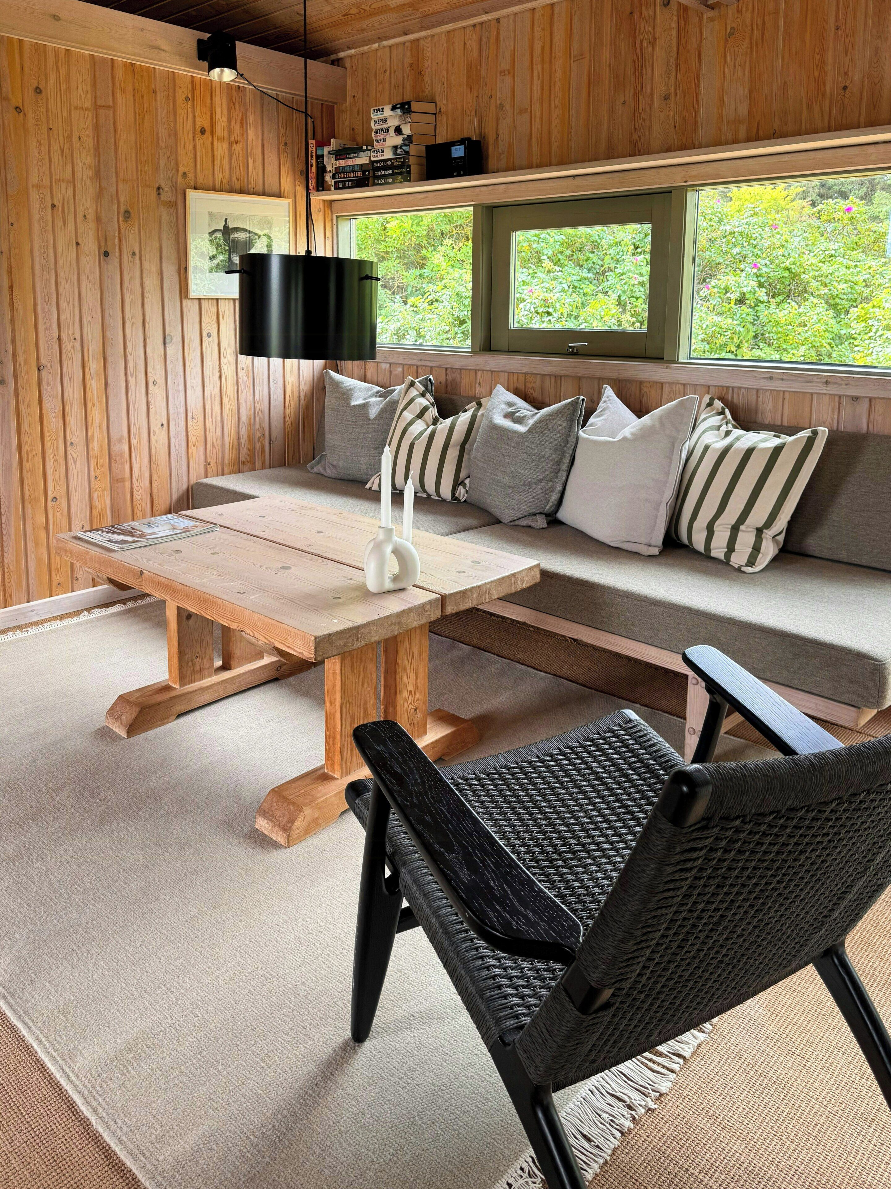 A wooden interior with a sofa, a table, and a chair.