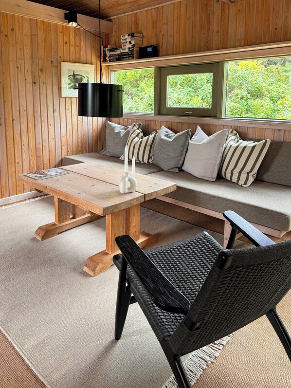 A wooden interior with a sofa, a table, and a chair. - House in Kettrup Bjerge near nature and the sea (Kettrup Bjerge)