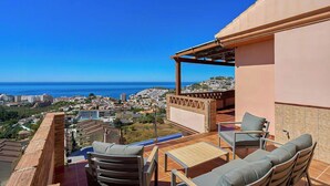 Una terraza con mobiliario exterior y vista al mar.