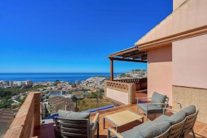 Eine Terrasse mit Gartenmöbeln und Meerblick.