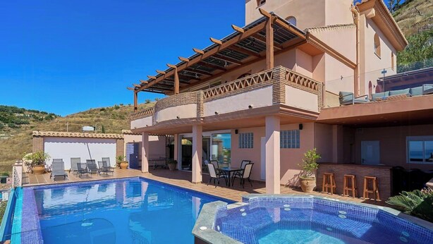 Una casa grande con piscina y jacuzzi.