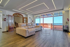 Ein modernes Wohnzimmer mit einer Couch, einem runden Tisch und einem großen Fenster mit Blick.