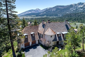 A large house with a stone tower, multiple chimneys, and a paved driveway. - Impressive Castle with Great Mountain Views and Foosball in Mammoth Lakes, California (Mammoth Lakes)