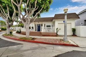 A residential house with a front porch, a garage, and a street lamp.