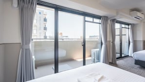A hotel room with a large bed, a balcony with curtains, and a view of the cityscape. - Eslead Hotel Namba Daikokucho Annex (Daikoku, Naniwa-ku, Osaka-shi)