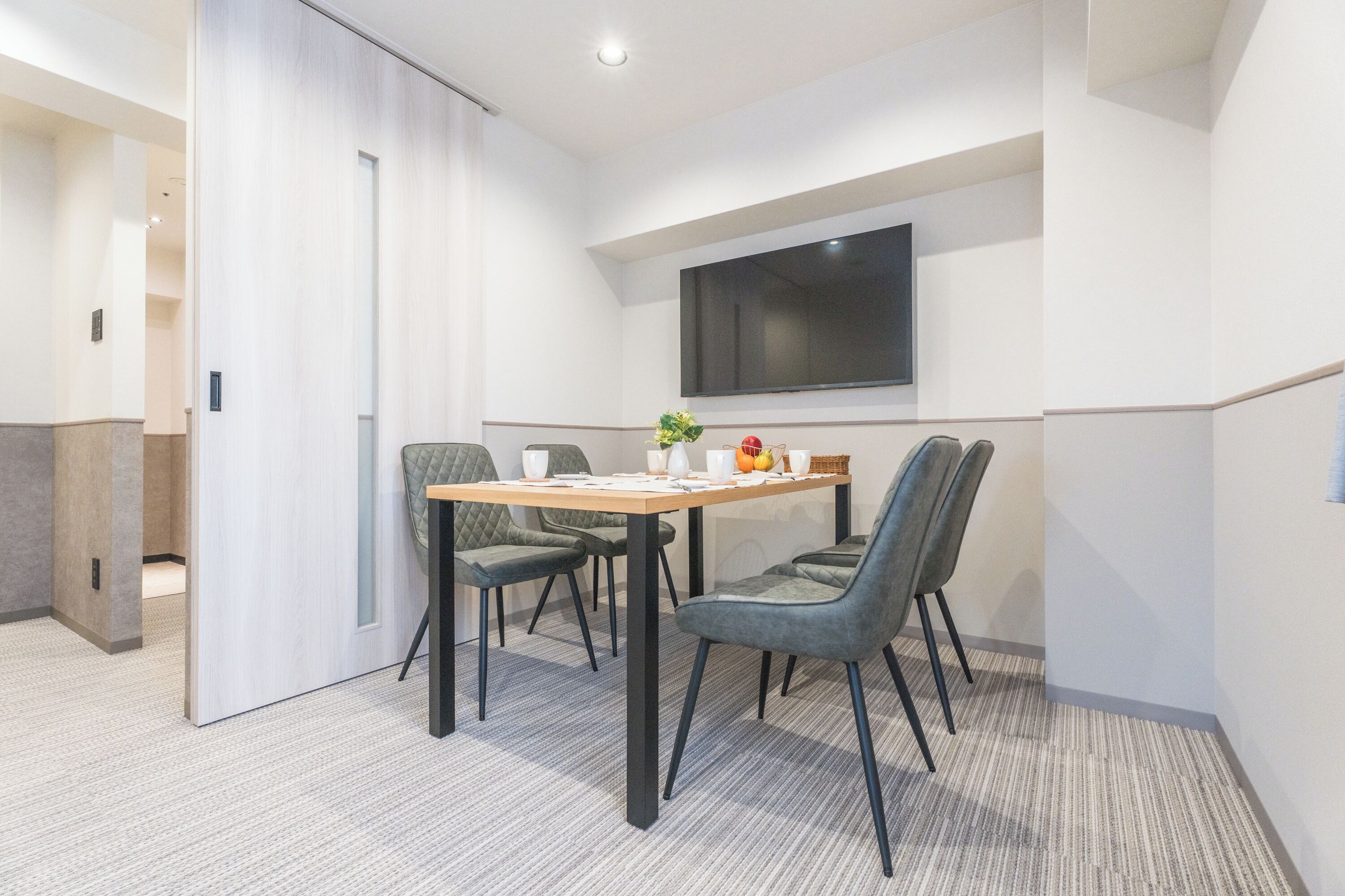 A modern dining area with a table, chairs, and a large window.