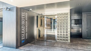 The entrance to the Eslead Hotel with a modern design, including a glass door and a display of circular objects. - Eslead Hotel Namba Daikokucho Annex (Daikoku, Naniwa-ku, Osaka-shi)