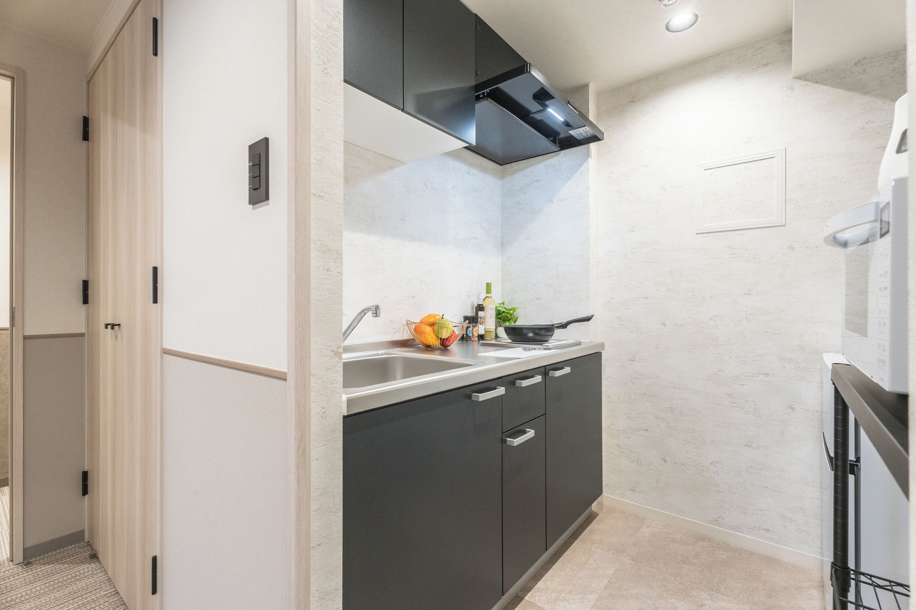A compact kitchen with a sink, stove, and cabinets.