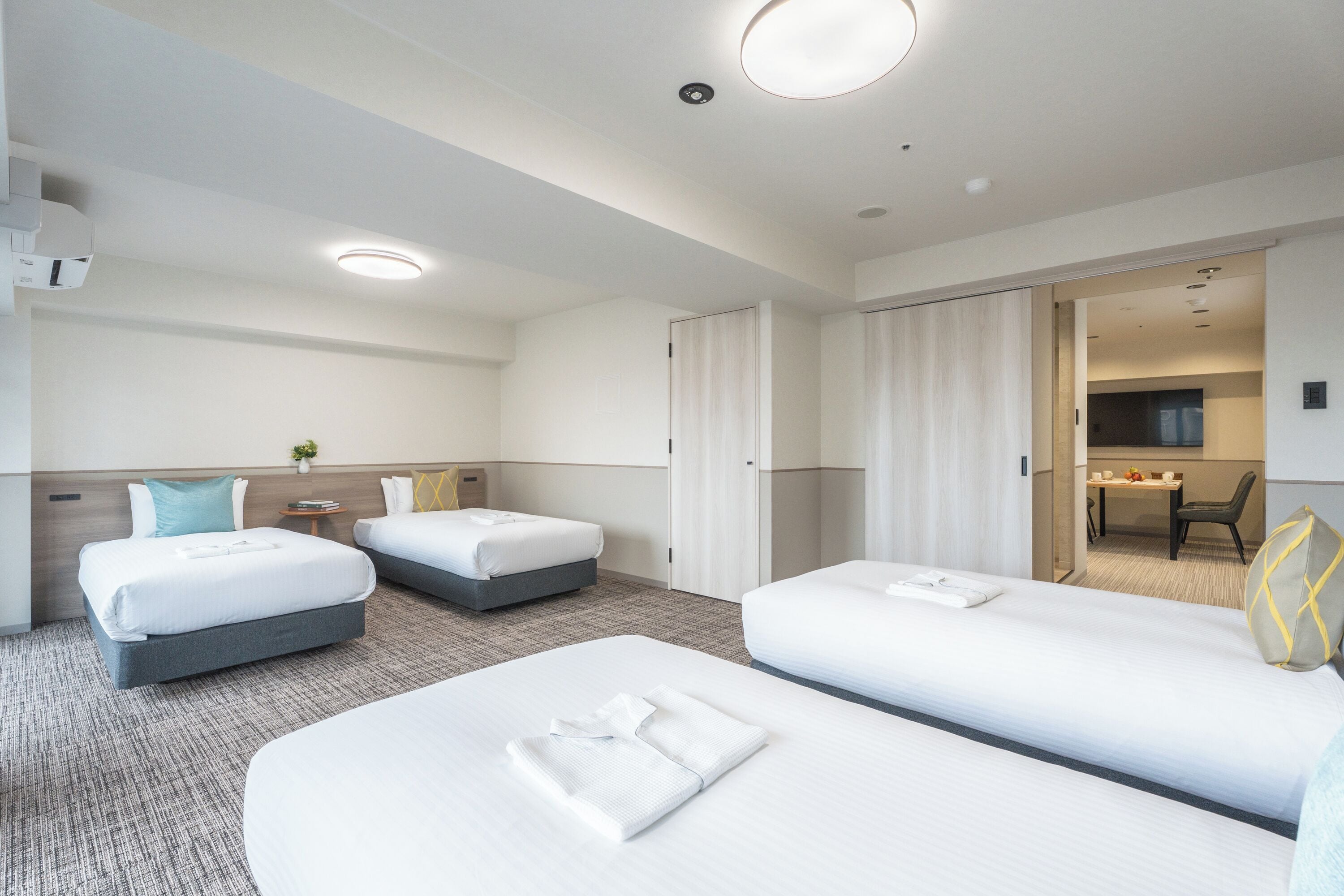 Una habitación de hotel con dos camas, un escritorio y un baño.