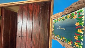 Uma porta de madeira com moldura rústica e uma placa decorativa com motivos florais.