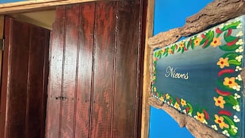 A wooden door with a rustic frame and a decorative sign with floral patterns.