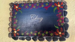 Paredes decorativas com uma borda floral pintada e a palavra 'Chay' ao centro.