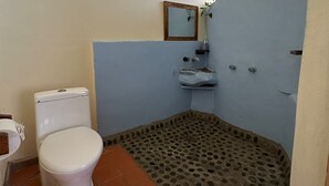 Ein Badezimmer mit Toilette, Waschbecken und Duschbereich.
