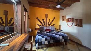 A room with a bed, wooden furniture, a mirror, and a ceiling fan. - Habitación Luisa (Segundo piso) (San Francisco)