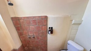 A small bathroom with a shower, toilet, and a bottle of hand sanitizer on the wall. - Habitación Beto-Segundo piso (San Francisco)