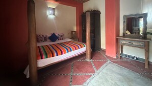 Quarto com cama, armário de madeira, espelho e ventilador de teto.