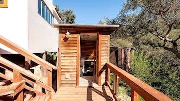 A wooden staircase leading to a building with a white exterior and a wooden deck.