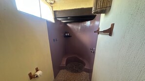 A small bathroom with a toilet, a shower, a towel rack, and a trash can. - Habitación Triny (Primer piso) (San Francisco)