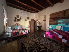 A room with a bed, a desk, a chair, a wardrobe, a mirror, and a wall with decorative items. - Habitación Ramon (Primer piso) (San Francisco)