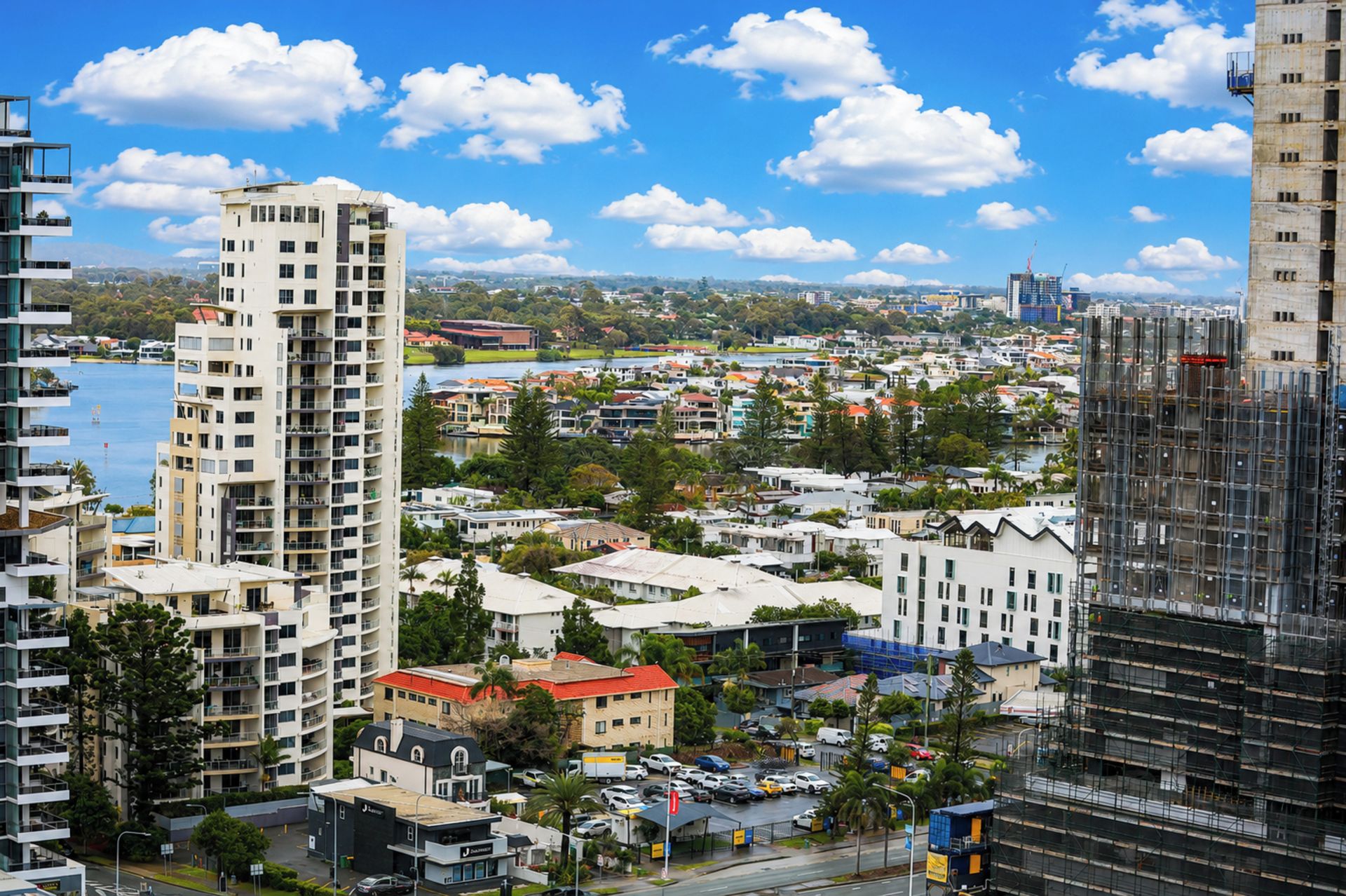 A high-rise building with multiple floors, surrounded by other buildings and a body of water.