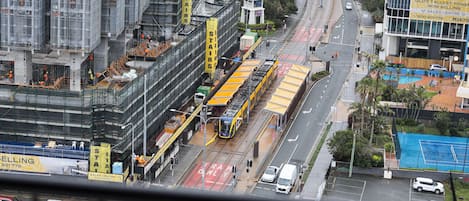 Calle urbana con tranvía, sitio de construcción y edificios, incluyendo un centro de ventas.