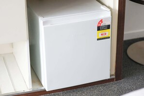 A white refrigerator with an ENERGY RATING sticker. - Beachside Studio with Stunning Ocean View (Surfers Paradise)