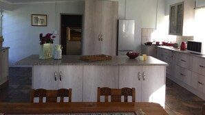 Una cocina con una isla central, armarios de madera, un refrigerador y un microondas.